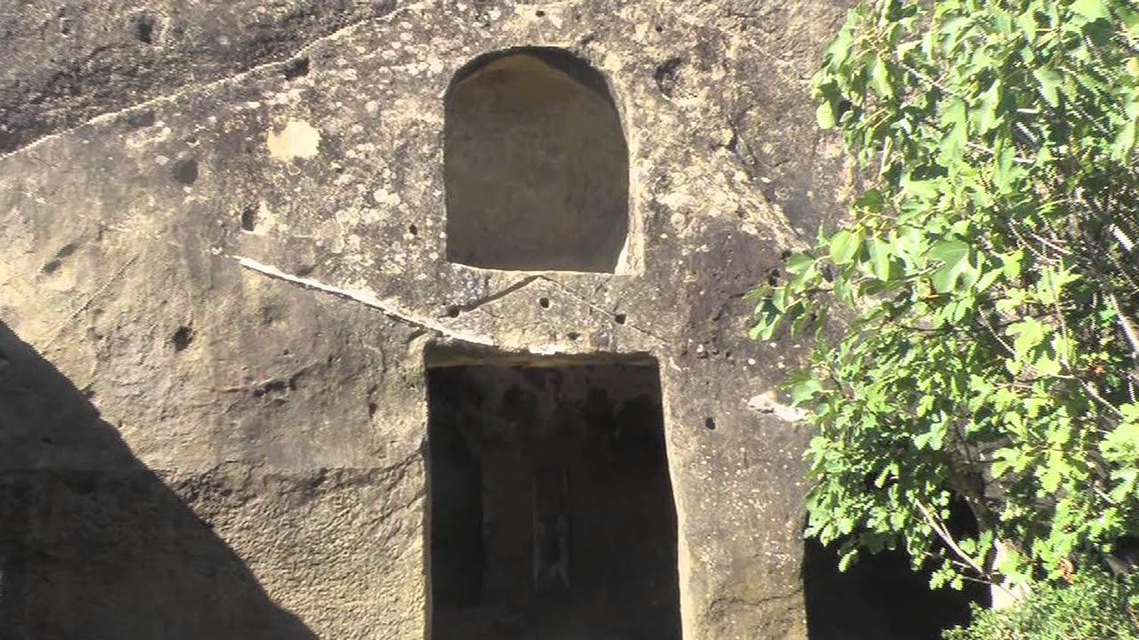 Panorámica exterior de la Casa de Piedra de Cortes de la Frontera mostrando el enorme bloque de arenisca del Aljibe en el que está excavado el monumento, Málaga, Andalucía